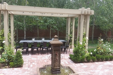 Inspiration for a mid-sized traditional brick formal garden in Other.
