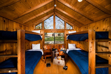 Ejemplo de dormitorio infantil rústico de tamaño medio con suelo de madera en tonos medios, madera y madera