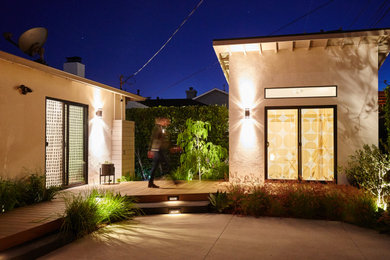 Imagen de terraza retro de tamaño medio en patio trasero y anexo de casas con jardín de macetas y adoquines de hormigón
