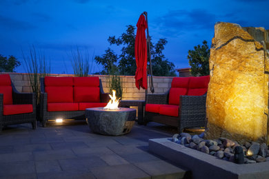 Example of a mid-sized zen backyard concrete paver patio design in Las Vegas with a fire pit