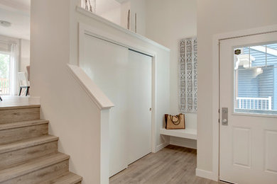Small transitional laminate floor and gray floor entryway photo in Edmonton with white walls and a white front door