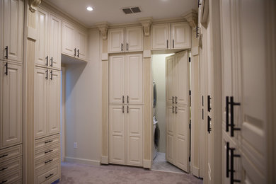 Elegant gender-neutral carpeted reach-in closet photo in Tampa with raised-panel cabinets and white cabinets