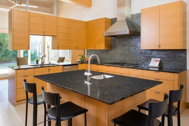 Inspiration for a mid-sized contemporary l-shaped eat-in kitchen in Dallas with a double-bowl sink, flat-panel cabinets, medium wood cabinets, black splashback, matchstick tile splashback, stainless steel appliances, ceramic floors, with island and granite benchtops.