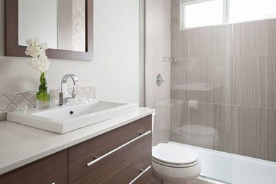 Photo of a contemporary 3/4 bathroom in Vancouver with flat-panel cabinets, brown cabinets, an open shower, a one-piece toilet, beige tile, ceramic tile, grey walls, engineered quartz benchtops, beige floor, an open shower, white benchtops, a single vanity, a built-in vanity and laminate floors.
