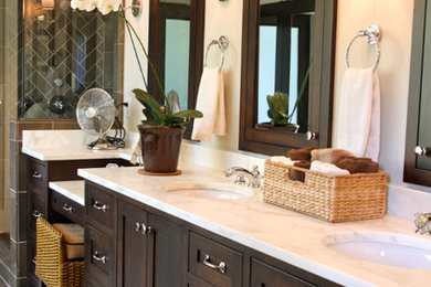 Large transitional master black tile and porcelain tile concrete floor and brown floor alcove shower photo in Atlanta with recessed-panel cabinets, dark wood cabinets, beige walls, an undermount sink, marble countertops and a hinged shower door