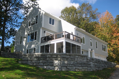 Example of a large classic gray three-story wood gable roof design in Manchester