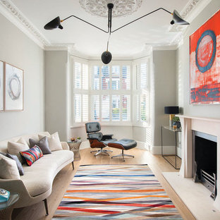 Inredning av ett modernt mellanstort separat vardagsrum, med gröna väggar, ljust trägolv, en standard öppen spis, beiget golv, ett finrum och en spiselkrans i gips