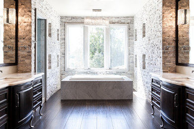 Drop-in bathtub - mediterranean gray tile and stone tile porcelain tile drop-in bathtub idea in Sacramento with an undermount sink, furniture-like cabinets, dark wood cabinets and white walls