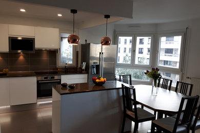 This is an example of a mid-sized modern l-shaped eat-in kitchen in Paris with a single-bowl sink, white cabinets, granite benchtops, brown splashback, ceramic floors, with island, brown floor and brown benchtop.