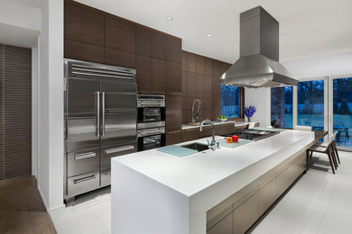 Inspiration for a large modern galley porcelain tile eat-in kitchen remodel in Chicago with a single-bowl sink, flat-panel cabinets, medium tone wood cabinets, solid surface countertops, stainless steel appliances and an island