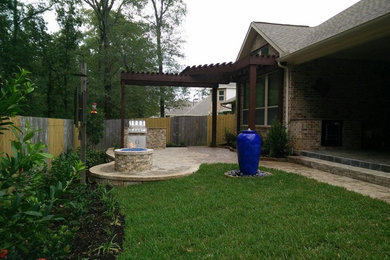 Mid-sized backyard brick patio photo in Houston with a fire pit and a pergola