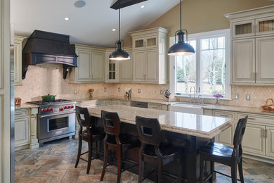 Huge elegant u-shaped ceramic tile and multicolored floor eat-in kitchen photo in Philadelphia with a farmhouse sink, raised-panel cabinets, white cabinets, granite countertops, beige backsplash, terra-cotta backsplash, stainless steel appliances and an island