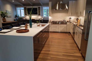 Design ideas for a mid-sized midcentury l-shaped eat-in kitchen in Raleigh with a single-bowl sink, flat-panel cabinets, grey cabinets, quartz benchtops, white splashback, glass tile splashback, stainless steel appliances, porcelain floors and with island.