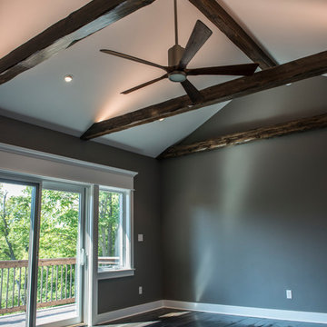 Bedroom with reclaimed wood beams and rustic hardwood