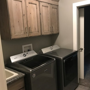 Photo of a medium sized rural l-shaped utility room in Cedar Rapids with a belfast sink, flat-panel cabinets, distressed cabinets and a side by side washer and dryer.