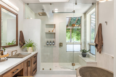 Example of a large trendy master white tile porcelain tile, white floor and double-sink bathroom design in Other with shaker cabinets, medium tone wood cabinets, a two-piece toilet, white walls, a drop-in sink, quartzite countertops, a hinged shower door, multicolored countertops and a built-in vanity