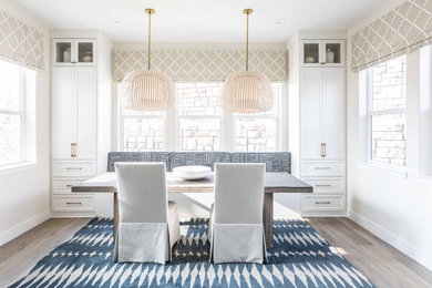 This is an example of a small transitional kitchen/dining combo in Sacramento with light hardwood floors, white walls and no fireplace.