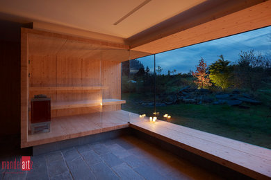 Große Moderne Sauna mit braunen Fliesen, brauner Wandfarbe, hellem Holzboden und braunem Boden in Köln