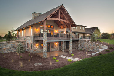 Example of a large classic backyard deck design in Denver with a roof extension