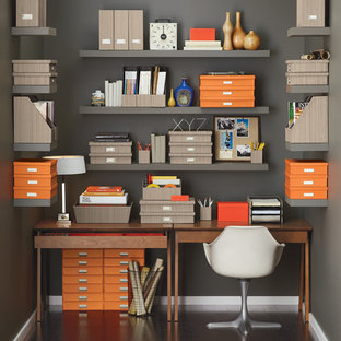 Inspiration för mycket stora 60 tals hemmabibliotek, med mörkt trägolv och grå väggar