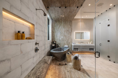 Example of a large minimalist master beige tile and porcelain tile porcelain tile, beige floor and single-sink bathroom design in Other with flat-panel cabinets, gray cabinets, beige walls, an integrated sink, solid surface countertops, a hinged shower door, a niche, a floating vanity and white countertops