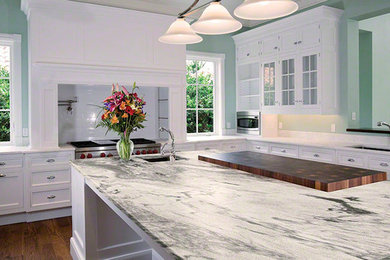 Inspiration for a mid-sized transitional l-shaped medium tone wood floor enclosed kitchen remodel in Boston with an undermount sink, beaded inset cabinets, white cabinets, marble countertops, white backsplash, subway tile backsplash, stainless steel appliances and an island