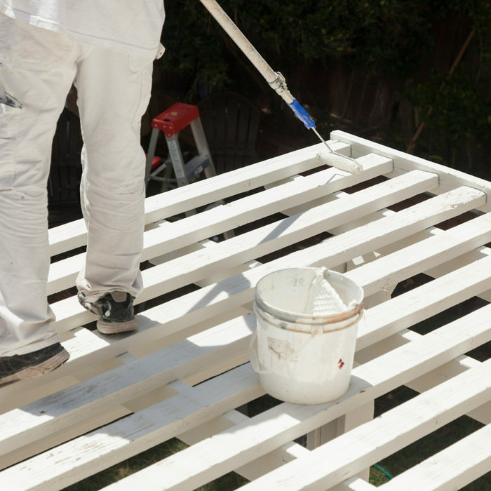 A man painting a deck
