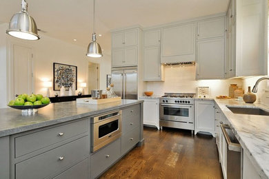 Large cottage l-shaped medium tone wood floor enclosed kitchen photo in San Francisco with an undermount sink, beaded inset cabinets, gray cabinets, soapstone countertops, white backsplash, subway tile backsplash, stainless steel appliances and an island