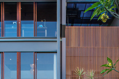 Inspiration for a large modern gray two-story wood exterior home remodel in Other with a mixed material roof