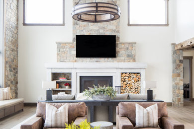 Living room - rustic open concept light wood floor living room idea in Jackson with a bar, a standard fireplace, a stone fireplace and a wall-mounted tv