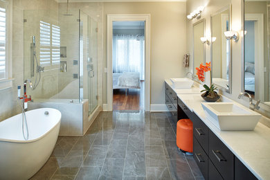 Large transitional master ceramic tile gray floor and marble floor bathroom photo in Charleston with flat-panel cabinets, dark wood cabinets, beige walls, a vessel sink, a hinged shower door and quartz countertops