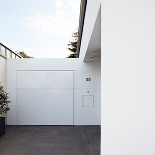 ケルンの片開きドアコンテンポラリースタイルのおしゃれな玄関 (白い壁、御影石の床、白いドア) の写真