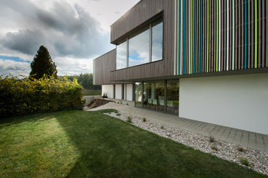 Große, Zweistöckige Moderne Holzfassade Haus mit brauner Fassadenfarbe und Flachdach