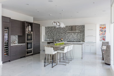 Example of a large trendy marble floor eat-in kitchen design in DC Metro with an undermount sink, flat-panel cabinets, gray cabinets, granite countertops, gray backsplash, ceramic backsplash, stainless steel appliances and an island