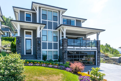 Transitional gray three-story concrete fiberboard house exterior photo in Vancouver with a hip roof and a shingle roof