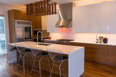 Inspiration for a mid-sized modern l-shaped dark wood floor and brown floor open concept kitchen remodel in San Diego with an undermount sink, flat-panel cabinets, dark wood cabinets, solid surface countertops, stainless steel appliances and an island