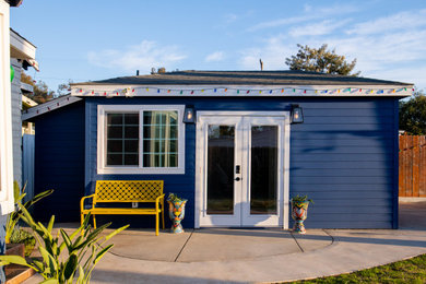 Small minimalist blue one-story tiny house photo in San Diego with a black roof