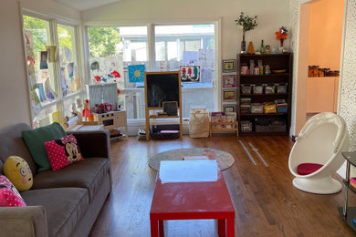 Example of a mid-sized transitional girl medium tone wood floor, brown floor and vaulted ceiling kids' room design in New York with white walls