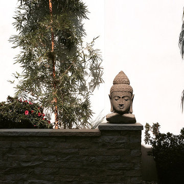stone-clad low landscape wall at smooth stucco courtyard