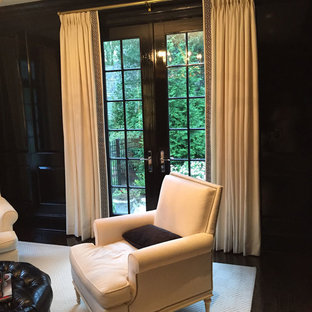 Mid-sized traditional study room in Philadelphia with black walls, a standard fireplace, a wood fireplace surround and carpet.