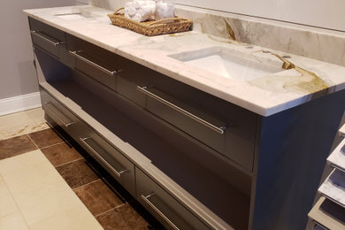 Inspiration for a mid-sized modern master gray tile and wood-look tile ceramic tile, brown floor and double-sink bathroom remodel in Atlanta with flat-panel cabinets, beige cabinets, gray walls, a drop-in sink, quartz countertops and a built-in vanity
