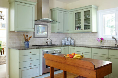 Example of a transitional l-shaped medium tone wood floor kitchen design in Chicago with an undermount sink, shaker cabinets, green cabinets, brick backsplash, stainless steel appliances and an island