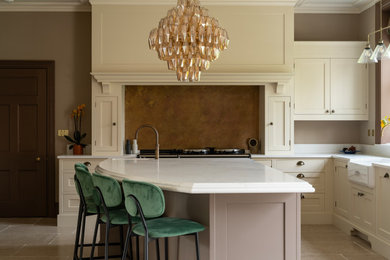Design ideas for a large traditional l-shaped kitchen/diner in Oxfordshire with a submerged sink, shaker cabinets, beige cabinets, quartz worktops, brown splashback, ceramic flooring, an island, beige floors, white worktops and feature lighting.