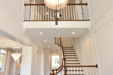 Example of a classic wooden u-shaped wood railing staircase design in Chicago with painted risers