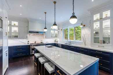 Large u-shaped dark wood floor and brown floor kitchen photo in Toronto with an undermount sink, white cabinets, quartzite countertops, white backsplash, stainless steel appliances and an island