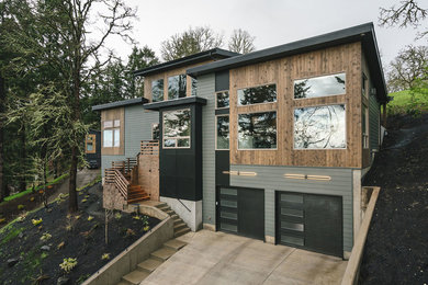 Inspiration for a large rustic gray two-story mixed siding house exterior remodel in Portland with a mixed material roof and a shed roof