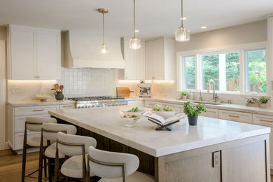 Open concept kitchen - transitional l-shaped medium tone wood floor and brown floor open concept kitchen idea in San Francisco with an undermount sink, shaker cabinets, white cabinets, quartzite countertops, white backsplash, stainless steel appliances, an island and white countertops