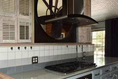 Example of an urban vaulted ceiling kitchen design in Other with raised-panel cabinets, gray cabinets, quartz countertops, multicolored backsplash, cement tile backsplash, stainless steel appliances and gray countertops