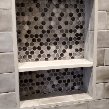Shower design done with penny rounds on the accent wall and shower floor