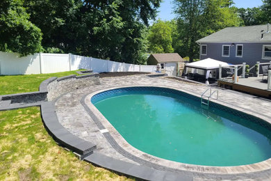 Foto de piscina moderna grande con paisajismo de piscina y adoquines de hormigón